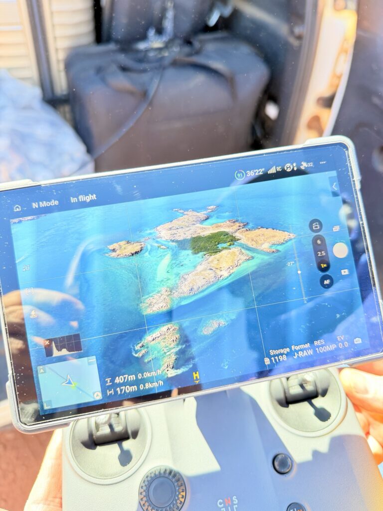 A drone controller screen showing islands and turquoise water from 400 metres up