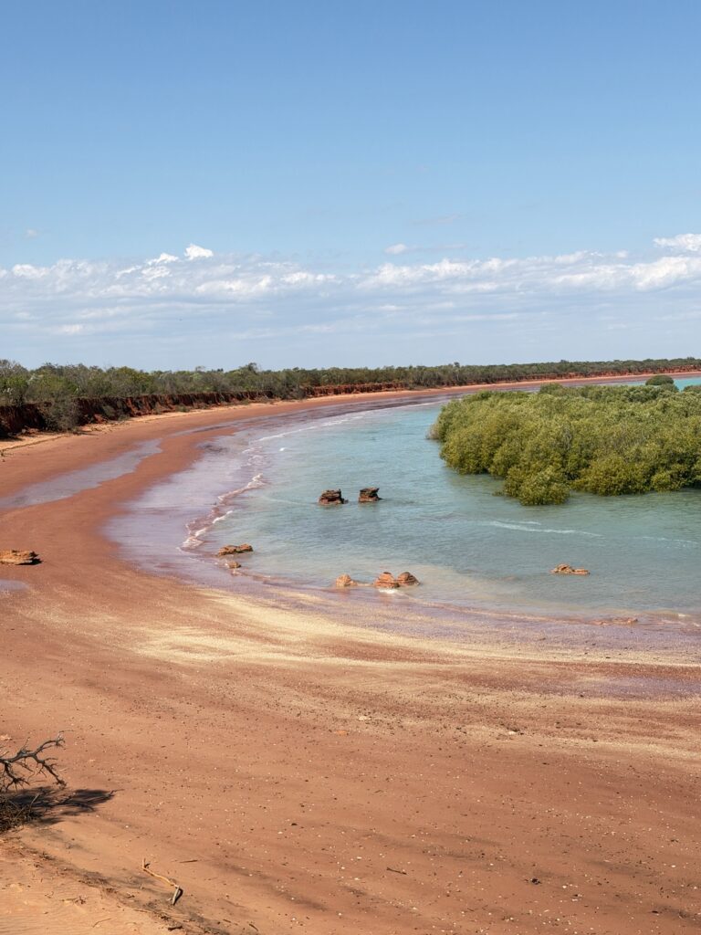 A sweep of red pindan cliffs, mangroves and clear water