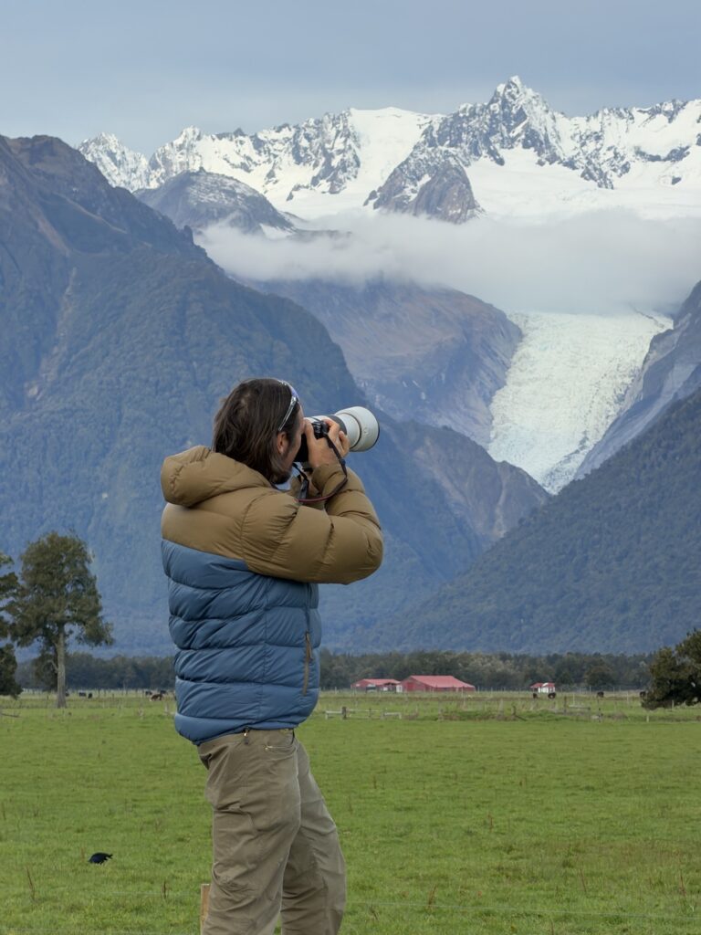 A guest shooting Fox Glacier with a long lens from the valley floor