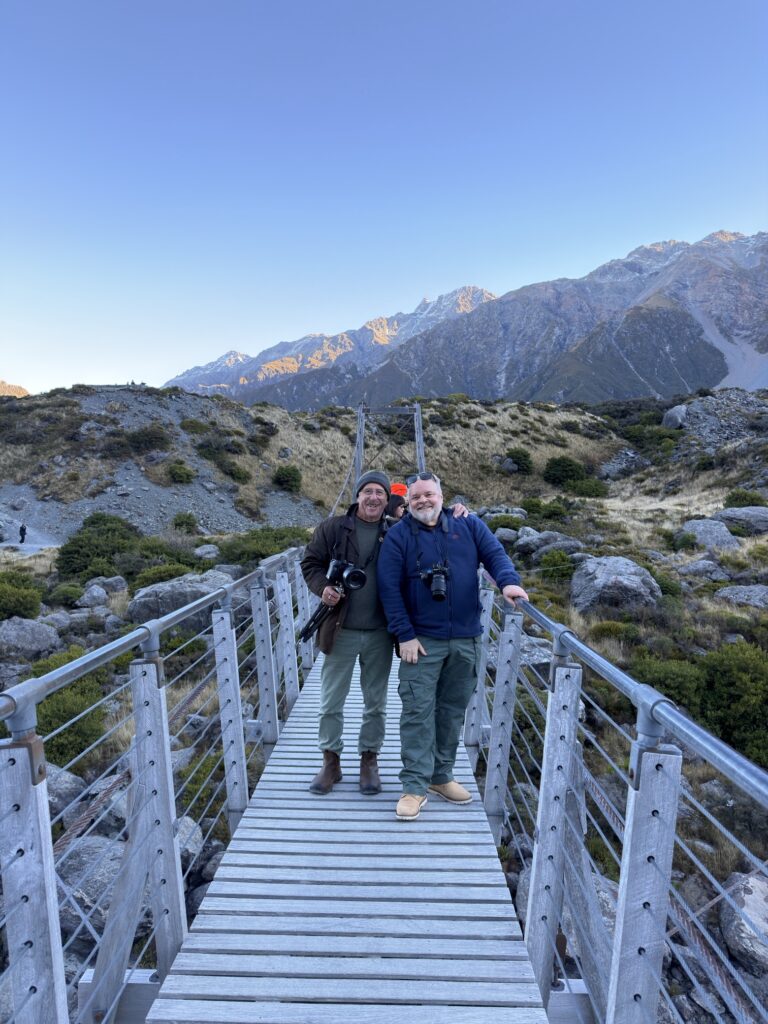 Two workshop guests on the Hooker Valley swing bridge at sunrise
