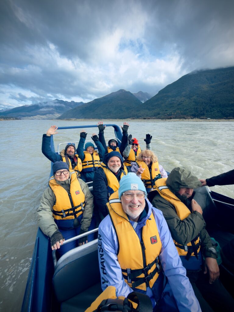 The group waving from a jet boat on a South Island river