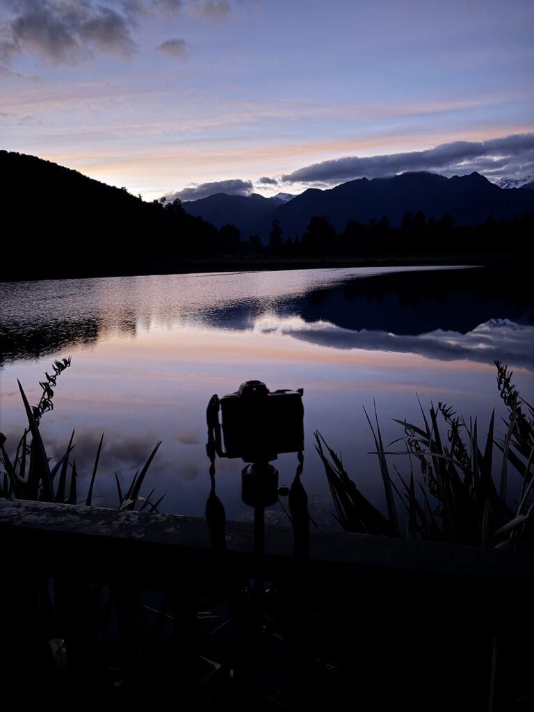 Camera on a tripod at Lake Matheson before sunrise